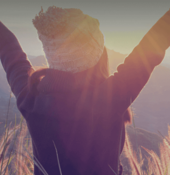 Mujer feliz frente a una puesta de sol 